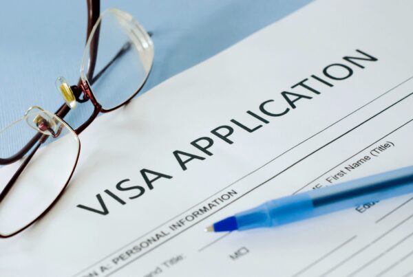 An image for a Visa Application with a blue ballpen and a red frameless eyeglasses